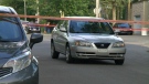 A car is parked behind police tape after a collision with a pedestrian in Ahuntsic-Cartierville on Thursday, June 30, 2022. (Cosmo Santamaria/CTV News)