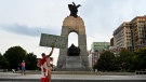 A protestor holds a sign reading 'Heros 2 Zeros' during a protest against COVID-19 health measures is seen at the National War Memorial in Ottawa, Ont. on Thursday, June 30, 2022. THE CANADIAN PRESS/Spencer Colby 