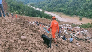 This photograph provided by India's National Disaster Response Force (NDRF) shows NDRF personnel and others trying to rescue those buried under the debris after a mudslide in Noney, northeastern Manipur state, India, June 30, 2022. (National Disaster Reponse Force via AP)