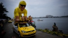 A giant cyclist, wearing the overall leader's yellow jersey, passes the Little Mermaid statue by Edvard Eriksen during the parade of sponsors prior to the first stage of the Tour de France cycling race, an individual time trial over 13.2 kilometres (8.2 miles) with start and finish in Copenhagen, Denmark, July 1, 2022. (AP Photo/Daniel Cole)