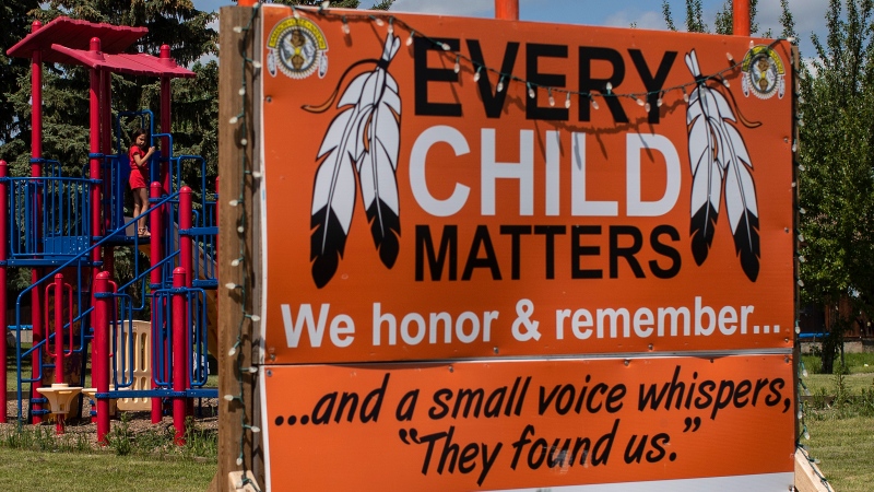 A young girl plays at a park where an Every Child Matters sign is in Maskwacis, Alta., Monday, June 27, 2022. The pope will be seeing the area on his visit in July. THE CANADIAN PRESS/Jason Franson