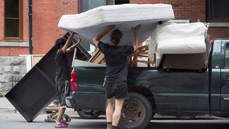 Two people move a bed onto a truck in Montreal, Friday, July 1, 2016, on what's now known as Moving Day in Quebec. THE CANADIAN PRESS/Graham Hughes