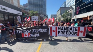 Hundreds of people march down Bank Street in downtown Ottawa on Canada Day as part of a protest over COVID-19 mandates. (Jeremie Charron/CTV News Ottawa)
