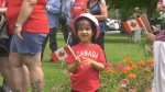 A child holds a Canada flag while watching the Canada Day Parade in Brockville, Ont. (Nate Vandermeer/CTV News Ottawa)