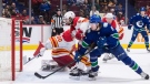 Vancouver Canucks' Brock Boeser (6) scores against Calgary Flames goalie Dan Vladar (80), of the Czech Republic, as Christopher Tanev (8) defends during the third period of an NHL hockey game in Vancouver, on Saturday, March 19, 2022. THE CANADIAN PRESS/Darryl Dyck