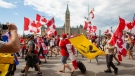 People protest and march in front of Parliament Hill against COVID-19 health measures during Canada Day in Ottawa, Ontario, on Friday July 1, 2022. THE CANADIAN PRESS/Lars Hagberg