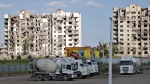 Cement trucks parked at a construction site of an apartment building under construction for residents of Mariupol affected by hostilities, in Mariupol, in territory under the government of the Donetsk People's Republic, eastern Ukraine, Friday, July 1, 2022. (AP Photo)