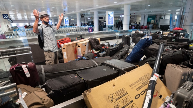 Jacques Bernier looks for his bicycle among a pile of unclaimed baggage at Pierre Elliott Trudeau airport, in Montreal, June 29, 2022. THE CANADIAN PRESS/Ryan Remiorz