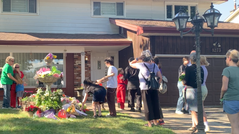 People place flowers at the home of Anne-Marie Ready and Jasmine Ready during a vigil for the Ottawa residents killed last Monday. (Jackie Perez/CTV News Ottawa) 
