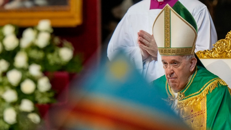 A nun waves a Democratic Republic of Congo flag as Pope Francis celebrates mass in St. Peter's Basilica for the Congolese community, at the Vatican on July 3, 2022. (AP Photo/Andrew Medichini)