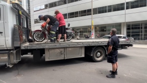 A motorcycle is loaded onto a truck in downtown Ottawa's vehicle control zone Saturday, July 2, 2022. (Jeremie Charron/CTV News Ottawa)
