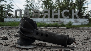 A part of the mortar shell is seen in front of a sign that reads 'Slovyansk,' after heavy fighting between pro-Russian fighters and Ukrainian government troops just outside Slovyansk, eastern Ukraine, on July 9, 2014. The eastern Ukrainian city of Slovyansk was occupied by pro-Russian separatists for months in 2014. Now its people are preparing to defend their community again as the fighting draws closer and invites a major battle. Slovyansk is a city of splintered loyalties, with some residents antagonistic toward Kyiv or nostalgic for their Soviet past. (AP Photo/Evgeniy Maloletka, File)