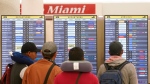 Travellers check their flights at Miami International Airport, July 2, 2022, in Miami. (AP Photo/Marta Lavandier)