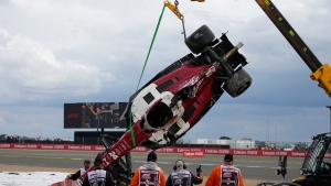 Track workers remove the car of Alfa Romeo driver Guanyu Zhou of China after a crash at the start of the British Formula One Grand Prix at the Silverstone circuit, in Silverstone, England on July 3, 2022. (AP Photo/Frank Augstein)