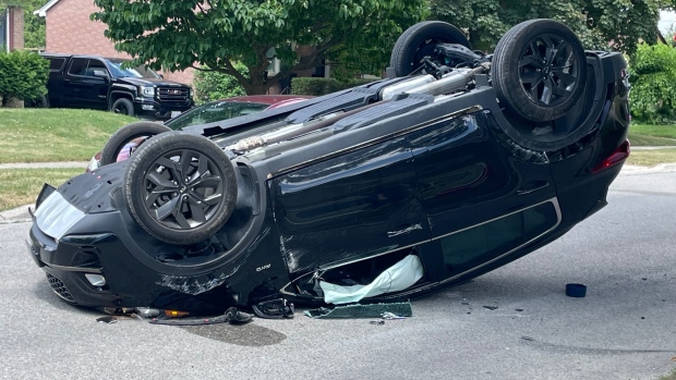 A vehicle rolled over after striking a tree in a residential neighbourhood on Chester Street in London, Ont. on July 3, 2022. (Sean Irvine/CTV News London)