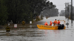A New South Wales State Emergency Service crew is seen in a rescue boat as roads are submerged under floodwater from the swollen Hawkesbury River in Windsor, northwest of Sydney, July 4, 2022. (Bianca De Marchi/AAP Image via AP)