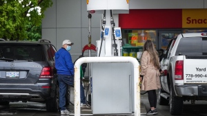 People fuel up vehicles at a Shell gas station. THE CANADIAN PRESS/Darryl Dyck