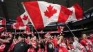 Fans wave Canadian flags before Canada and Curacao play a CONCACAF Nations League soccer match, in Vancouver, June 9, 2022. THE CANADIAN PRESS/Darryl Dyck
