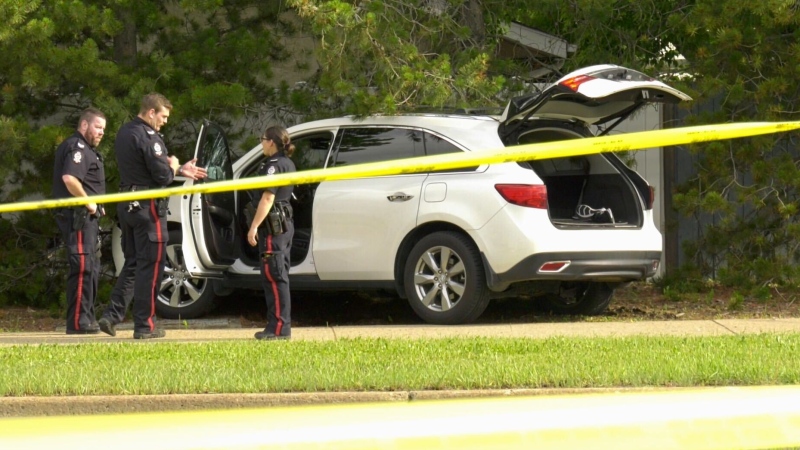 Police officers investigate a white SUV in northeast Edmonton involved in a drive-by shooting (CTV News Edmonton/Sean Amato).