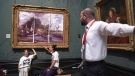 A security guard looks at protesters who glued their hands to the frame of John Constable's The Hay Wain, inside the National Gallery, London, Monday July 4, 2022. (Kirsty O'Connor/PA via AP)