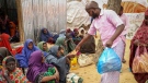 Somalis who fled drought-stricken areas receive charitable food donations from city residents after arriving at a makeshift camp for the displaced on the outskirts of Mogadishu, Somalia Thursday, June 30, 2022. (AP Photo/Farah Abdi Warsameh)