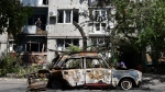 A destroyed car lies next to an apartment building damaged by an overnight missile strike in Sloviansk, Ukraine, Tuesday, May 31, 2022. (AP Photo/Andriy Andriyenko)