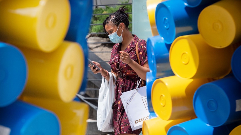 A woman wears a face mask as she walks by an art installation in Montreal, Sunday, June 13, 2021, as the COVID-19 pandemic continues in Canada and around the world. THE CANADIAN PRESS/Graham Hughes