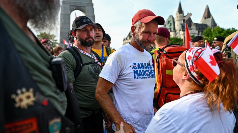 Army reservist James Topp speaks to a protestor during a protest against COVID-19 health measures at the National War Memorial in Ottawa on Thursday, June 30, 2022. THE CANADIAN PRESS/Spencer Colby