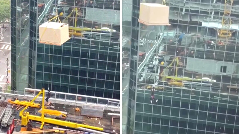 Construction worker dangles from crane in Toronto