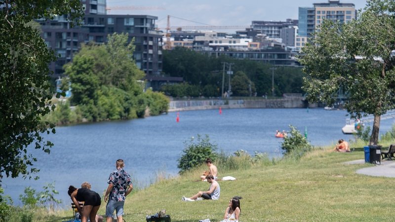 People enjoy the good weather by the Lachine Canal in Montreal, Saturday, July 2, 2022. THE CANADIAN PRESS/Graham Hughes