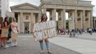 A woman holds a poster as she attends a demonstration against the United States Supreme Court decision to overturn Roe v. Wade in front of the Brandenburg Gate near the U.S. embassy in Berlin, Germany, Tuesday, July 5, 2022. (AP Photo/Markus Schreiber)