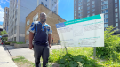 Lionel Njeukam standing next to the applicant’s proposal sign at his home at 142 Nepean St. (Peter Szperling/CTV News Ottawa)