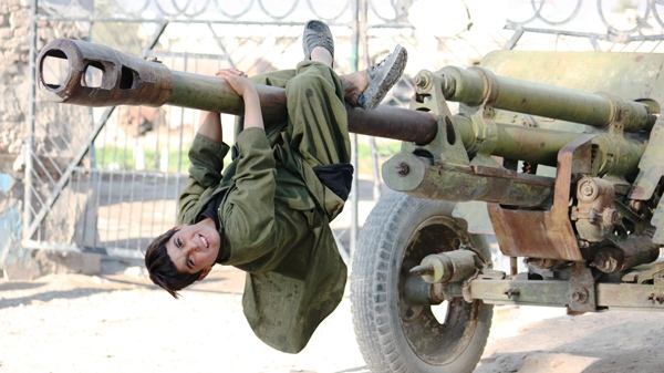 A boy hangs from the barrel of an abandoned Soviet cannon at an Afghan army compound in the heart of Kandahar, Afghanistan, on Thursday, Dec. 17, 2009. (Colin Perkel /  THE CANADIAN PRESS)