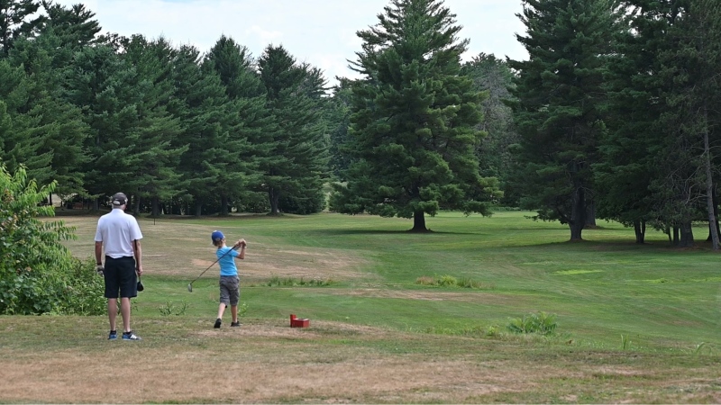 A grandfather golfs with his grandson at the recently reopened Norway Bay Golf Course. (Joel Haslam/CTV News Ottawa)