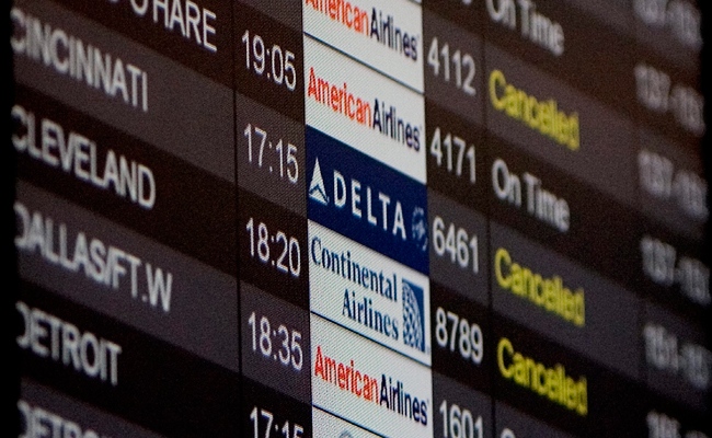 A passenger infomation board details some disruption at Pearson International Airport on as several airlines flying to the United States experience delays and cancellations, Monday, Dec. 28, 2009. (Chris Young / THE CANADIAN PRESS)