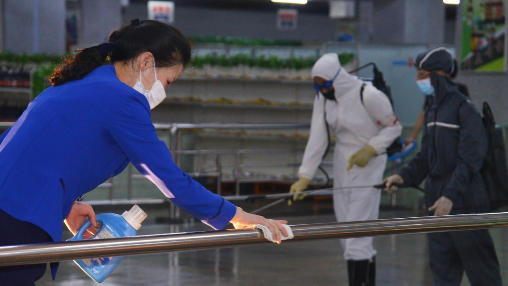 North Korean employees disinfect a facility