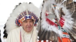 Pope Francis wears a traditional headdress he was given after his apology to Indigenous people during a ceremony in Maskwacis, Alta., as part of his papal visit across Canada on Monday, July 25, 2022. THE CANADIAN PRESS/Nathan Denette