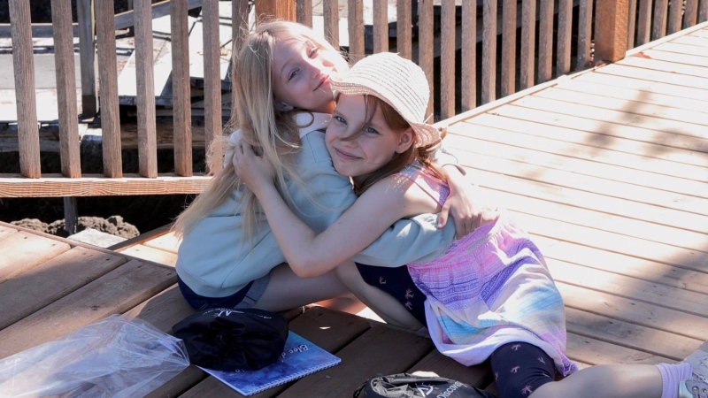 Two Ukrainian children embrace at a summer camp put on at the Ukrainian Safe Haven in East Sooke, B.C. (CTV News)