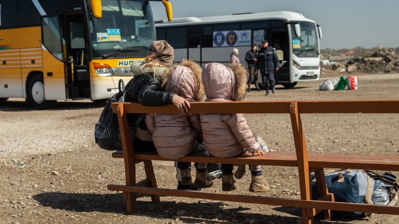 An Ukrainian mother and her daughters are seen waiting for a bus at a transit point for refugees in Palanca, south Moldova, on March 27. (Matteo Placucci/NurPhoto/Getty Images/CNN)