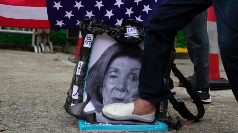 Pro-China supporters step on a picture of U.S. House Speaker Nancy Pelosi during a protest outside the Consulate General of the United States in Hong Kong, on Aug. 3, 2022. (Kin Cheung / AP) 