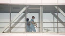 Health-care workers walk across a sky bridge at a hospital in Montreal, Sunday, February 6, 2022, as the COVID-19 pandemic continues in Canada. THE CANADIAN PRESS/Graham Hughes 