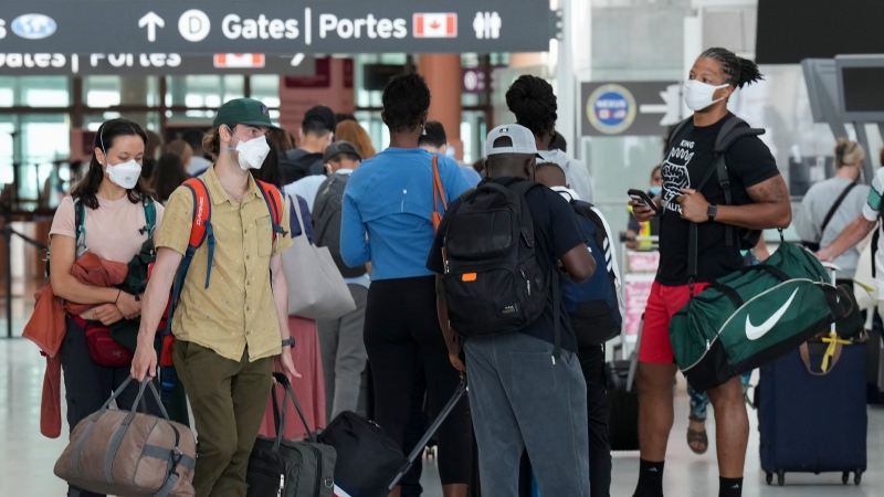 People line up before entering the security at Pearson International Airport in Toronto on Friday, August 5, 2022. THE CANADIAN PRESS/Nathan Denette 