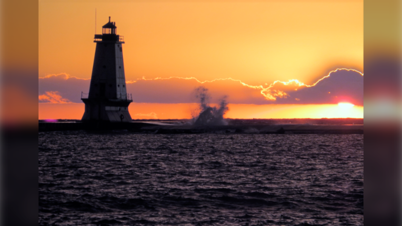 The sun sets and a wave crests over a lighthouse in Ontario in this viewer-submitted photo from August 2022. (Source: Milt Everitt)