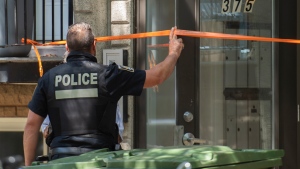 A police officer is shown at an apartment building in Montreal, Sunday, August 7, 2022, where a person apparently lost their life in an altercation with another person. THE CANADIAN PRESS/Graham Hughes