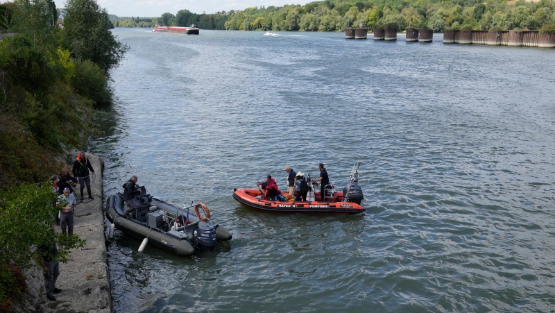 French fire brigade tracking on rubber boats a Beluga whale on the Seine river in Saint-Pierre-la-Garenne, west of Paris, Friday, Aug. 5, 2022. (AP Photo/Francois Mori)