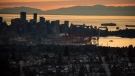 A Seabus passenger ferry, right, travels across Burrard Inlet at sunset as downtown Vancouver and the port are seen from Burnaby Mountain, on Monday, July 11, 2022. THE CANADIAN PRESS/Darryl Dyck