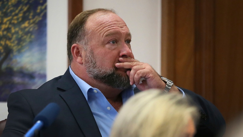 Alex Jones attempts to answer questions about his text messages asked by Mark Bankston, lawyer for Neil Heslin and Scarlett Lewis, during trial at the Travis County Courthouse in Austin, Wednesday Aug. 3, 2022. (Briana Sanchez/Austin American-Statesman via AP, Pool)