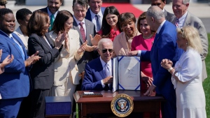 U.S. President Joe Biden holds the 'CHIPS and Science Act of 2022' after signing it during a ceremony on the South Lawn of the White House, on Aug. 9, 2022. (Evan Vucci / AP) 