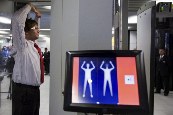 In this photo taken Monday, Dec. 28, 2009, an employee of Schiphol stands inside a body scanner during a demonstration at a press briefing at Schiphol airport, Netherlands. On display the highlighted area shows an alert on possible forbidden items. (AP Photo/Cynthia Boll)