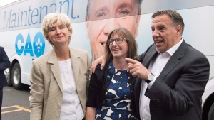 Coalition Avenir Quebec Leader Francois Legault, right, hugs local candidate Marie Eve Proulx, centre as he and his wife Isabelle Brais, right, arrive at a hardwood floor plant, Wednesday, August 29, 2018 in Montmagny Que. THE CANADIAN PRESS/Jacques Boissinot